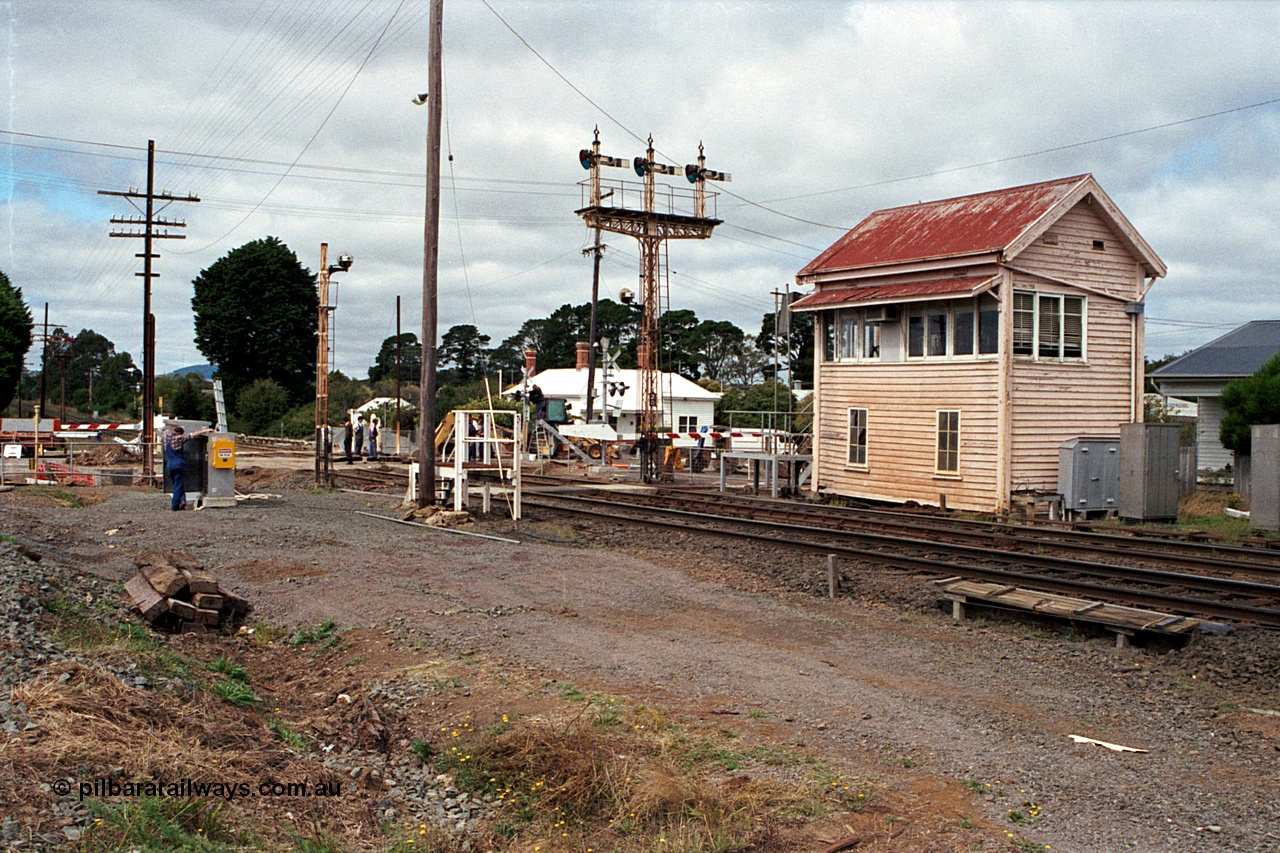 171-02
Ballarat, Linton Junction signal box Gillies St, work site view, interlocked gates being replaced by boom barriers, view of signal box, triple doll semaphore signal Post 20, Timken's Siding disc signal Post 21, staff exchange platform and auto exchange apparatus cover open, track view.
