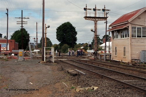 171-03
Ballarat, Linton Junction signal box Gillies St, work site view, interlocked gates being replaced by boom barriers, view of signal box, triple doll semaphore signal Post 20, Timken's Siding disc signal Post 21, staff exchange platform and auto exchange apparatus cover open, track view.
