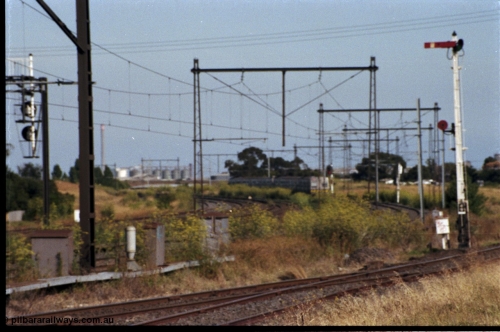 172-02
Sunshine, broad gauge Melbourne metropolitan electric service operated by 'The Met', this up Hitachi 6 car 'spark' or electric train rounds the curve east of Sunshine as it heads to Tottenham, signal post 49 controls up trains on the Sunshine - Newport Loop Line, with the disc controlling access to the GEB sidings, the points facing the camera leads to the main running lines and the Sunshine yard or what remained of it.
