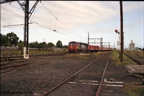 172-05
Sunshine, broad gauge V/Line N class N 470 'City of Wangaratta' Clyde Engineering EMD model JT22HC-2 serial 86-1199 leads a down passenger service with the unusual consist of 2 D vans, 4 car N set and another D van, the former Sunshine yard ends where I'm standing with the access to the Newport - Sunshine Loop Line running down the right hand side.
Keywords: N-class;N470;Clyde-Engineering-Somerton-Victoria;EMD;JT22HC-2;86-1199;