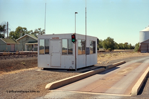 173-18
Murchison East, modern road vehicle weighbridge with portable cabin and traffic lights for weighing of in-bound grain receivals, station building and goods shed behind.
