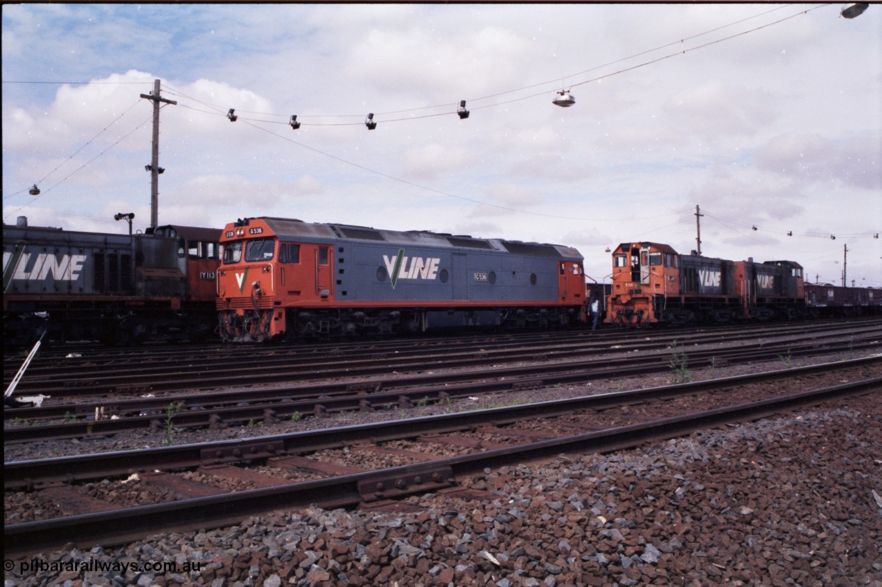 177-04
Tottenham Yard, view from the middle of the yard of broad gauge Clyde Engineering EMD model G6B V/Line shunt locomotives of the Y class, Y 130 serial 65-396 with a green louvre van and Y 118 serial 63-308 and Y 171 serial 68-591 as they go about Saturday morning shunting duties. In the final years of V/Line operation, the Y class were operated in pairs to shunt Tottenham Yard.
Keywords: G-class;G536;Clyde-Engineering-Somerton-Victoria;EMD;JT26C-2SS;88-1266;