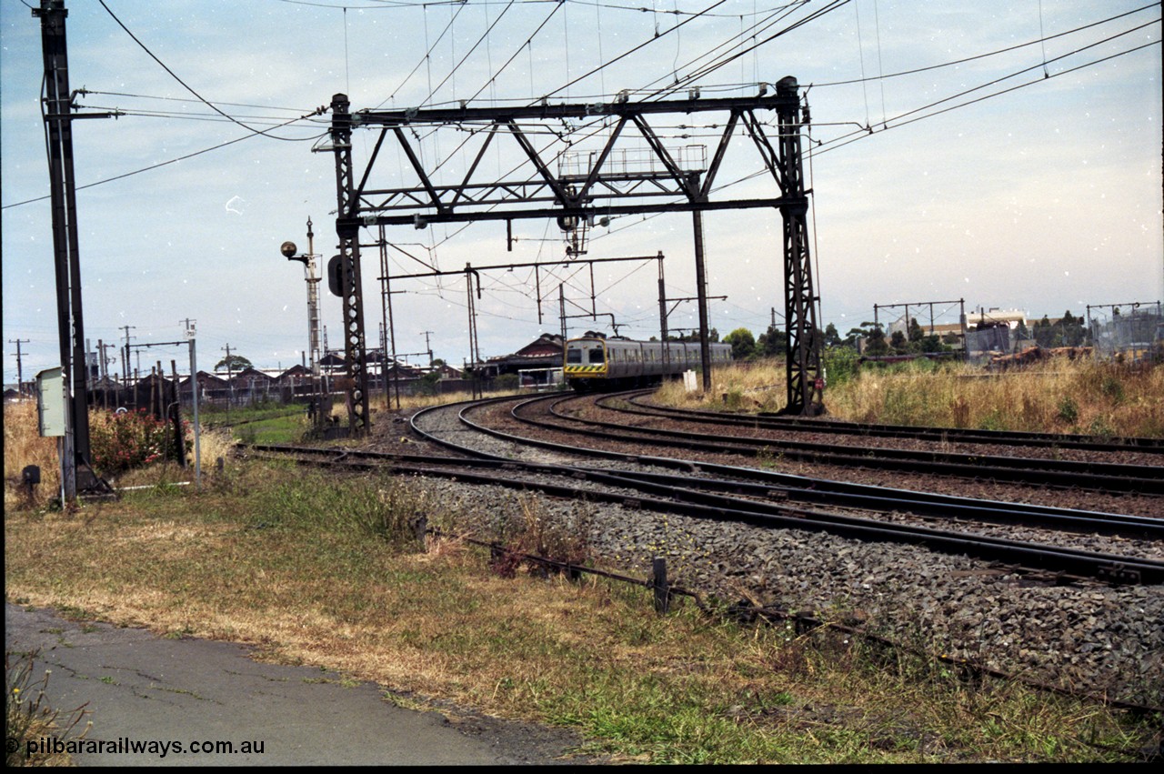 177-11
Newport, track view looking at Geelong - Werribee line, Newport Railway Workshops in the background, an up Werribee 3 car Comeng electric train is rounding the curve in 'The Met' livery.
