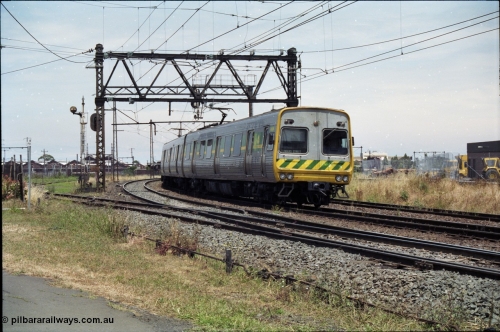 177-12
Newport, track view looking at Geelong - Werribee line, Newport Railway Workshops in the background, an up Werribee 3 car Comeng electric train is rounding the curve in 'The Met' livery.
