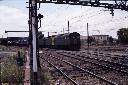 177-14
Newport, looking towards Melbourne, V/Line broad gauge down goods train 9169 creeps under the Melbourne Road overpass behind a pair of Australian National BL class locomotives BL 27 Clyde Engineering EMD model JT26C-2SS serial 83-1011 and class leader BL 26 'Bob Hawke' serial 83-1010, with a V/Line S and X class rounding out the motive power.
Keywords: BL-class;BL27;Clyde-Engineering-Rosewater-SA;EMD;JT26C-2SS;83-1011;