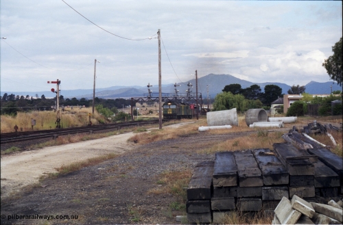 178-15
Ararat, track view looking east as V/Line broad gauge goods train 9169 to Adelaide arrives off the Portland line under the signal gantry with semaphore signal post 4 pulled off behind Australian National BL class locomotives BL 27 Clyde Engineering EMD model JT26C-2SS serial 83-1011 and class leader BL 26 'Bob Hawke' serial 83-1010 and V/Line S class S 313 'Alfred Deakin' Clyde Engineering EMD model A7 serial 61-230 and X class X 53 Clyde Engineering EMD model G26C serial 75-800, semaphore signal post 7 is for the Avoca line, which can be seen curving away around to the left, taken from the former Works and Cattle Sidings area.
