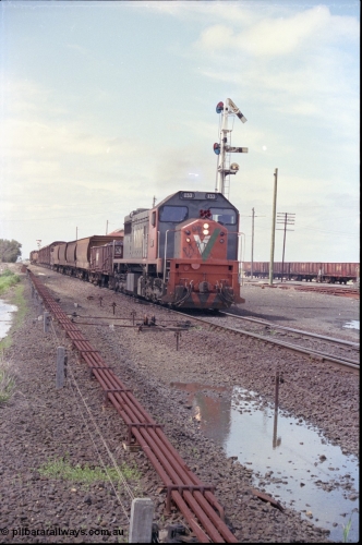 179-06
Gheringhap, yard overview looking east, broad gauge V/Line down goods train 9153 departs for Maroona with the signal on post 4 pulled off and the points are set for the Maroona line, point rodding and interlocking is spaced away from the line as this location used to have double mainlines, on the right are gypsum waggons in Sidings B.
Keywords: X-class;X53;Clyde-Engineering-Rosewater-SA;EMD;G26C;75-800;