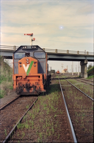 179-19
Gheringhap, station yard overview looking east from the Ballarat line and Siding C, the line to Maroona is on the right, in the back ground semaphore signal post 4 is pulled of for down goods train 9169 to depart, V/Line broad gauge X class locomotive X 51 Clyde Engineering EMD model G26C serial 75-798 is awaiting light engines from Geelong to come and retrieve it.
Keywords: X-class;X51;Clyde-Engineering-Rosewater-SA;EMD;G26C;75-798;