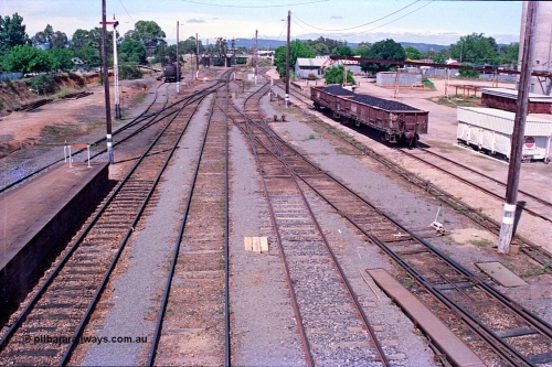 180-14
Wangaratta, yard view looking south from the southern footbridge, shows the Car Dock at left, with the standard gauge line and platform in the cutting at the far left, semaphore signal post 12, a VTQF type bogie fuel waggon in the oil company siding, with pipe gantry bridge over the SG line.
Keywords: VTQF-type;