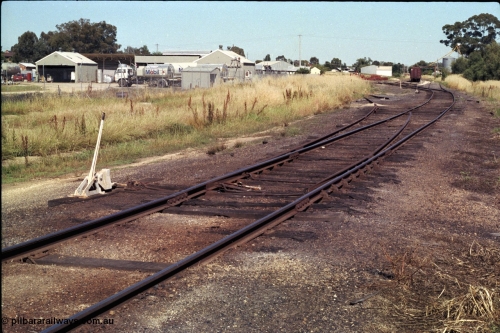 182-05
Wahgunyah, station yard overview looking north along the mainline, redundant points with lever and hand locking bar still in-situ but K crossing removed, former track to Mobil Oil Company Siding, silo complex and waggon rake in the distance.
