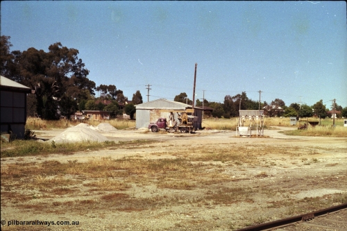 182-08
Wahgunyah, super phosphate storage sheds, with piles and unloading contraption on the back of a Bedford J series truck, bag filling platform, Caltex depot in middle background.
