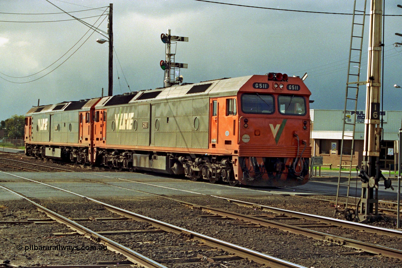185-16
North Geelong C Box, Separation Street grade crossing, V/Line light engines, G class leader G 511 Clyde Engineering EMD model JT26C-2SS serial 84-1239 and younger sister G 534 serial 88-1264 shunt from the Gheringhap line back into North Geelong Yard past semaphore signal post 14, the disc signal can be just seen to be pulled off.
Keywords: G-class;G511;Clyde-Engineering-Rosewater-SA;EMD;JT26C-2SS;85-1239;