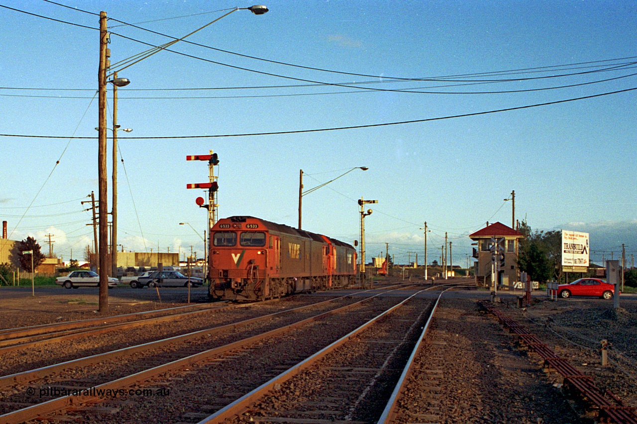 185-32
North Geelong C Box, Separation Street grade crossing, a pair of V/Line G class units G 533 Clyde Engineering EMD model JT26C-2SS serial 88-1263 and a sister shunt back into North Geelong Yard light engine to form grain train 9125.
Keywords: G-class;G533;Clyde-Engineering-Somerton-Victoria;EMD;JT26C-2SS;88-1263;