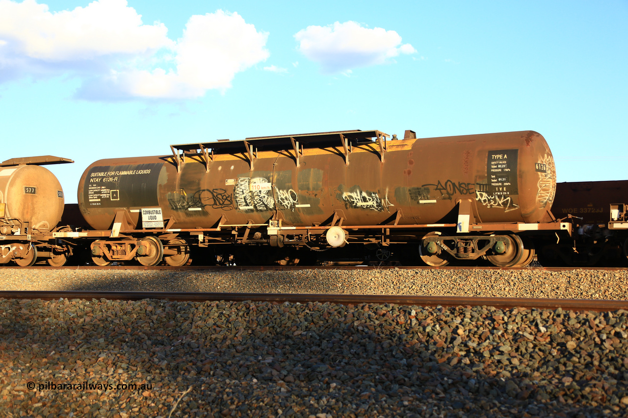 240328 3197
West Kalgoorlie, Viva Energy's NTAY type fuel tank waggon NTAY 6126 built by Indeng, Qld in 1976, in a batch of four, for Shell as an SCA type 65,000 litre one compartment oil tank SCA 277. Recoded to NTAF 277, then NTAF 6126. Diesel capacity of 61,300 litres. Freight Australia painted out in middle of tank and fitted with conventional couplers. Pacific National empty fuel train 5445 to Esperance. March 28, 2024.
Keywords: NTAY-type;NTAY6126;Indeng-Qld;SCA-type;SCA277;NTAF-type;