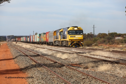160523 2927
Parkeston, 7SP3 intermodal train, a pair of Goninan built GE model Cv40-9i NR class units NR 12 serial 7250-02/97-214 and NR 51 serial 7250-08/97-253 lead the train 'elephant style' out of the dip and along the mainline at the 1776 km. The PN local is in the car at the gantry performing a roll-by, the track on the left is the Engineers Siding.
Keywords: NR-class;NR12;Goninan;GE;Cv40-9i;7250-02/97-214;