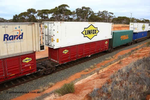 160524 3798
West Kalgoorlie, 2PM6 intermodal train, RRGY 7125 platform 4 of 5-pack articulated skeletal waggon set, one of fifty originally built by AN Rail Islington Workshops in 1996-97 as type RRBY, later rebuilt with 48' intermediate decks and recoded to RRGY, with a Linfox 40' half height side door LSDU 6940087 double stacked with a Linfox 46' 6