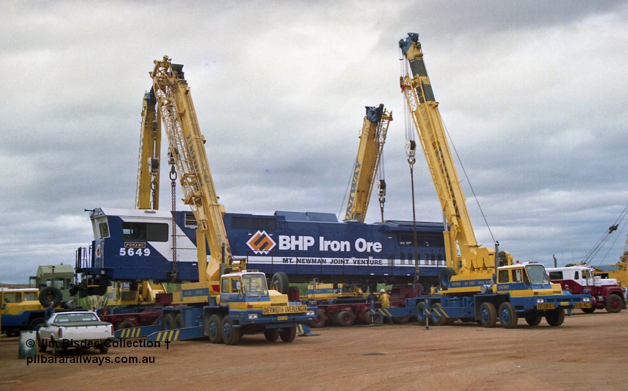 23884
Bassendean, Goninan workshops, BHP Iron Ore GE CM40-8M rebuild unit 5649 'Pohang' serial 8412-07 / 93-140 is lifted up with the Bell road transport float being prepped underneath for road haulage to Port Hedland. 5649 was rebuilt from AE Goodwin ALCo M636 unit 5473 serial G6047-5. July 1993.
Jim Bisdee photo.
Keywords: 5649;Goninan;GE;CM40-8M;8412-07/93-140;rebuild;AE-Goodwin;ALCo;M636C;5473;G6047-5;