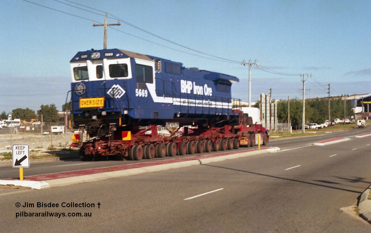 24135
Bassendean, Collier Road, Key Transport hauling the final BHP Iron Ore Goninan GE rebuilt CM40-8M unit 5669 serial 8412-02 / 95-160, which is actually an CM40-8MEFI as the final three had electronic fuel injection fitted to their 7FDL-16 engines. 5669 was rebuilt from Comeng NSW built ALCo M636 model 5486 serial C6084-2. July 1995.
Jim Bisdee photo.
Keywords: 5669;Goninan;GE;CM40-8EFI;8412-02/95-160;rebuild;Comeng-NSW;ALCo;M636C;5486;C6084-2;