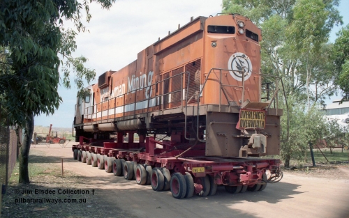 20859
Bassendean, Goninan workshops, sitting outside the locked gates having just been bought down from Port Hedland, Mt Newman Mining's AE Goodwin ALCo C636 unit 5454 serial G6012-3 on a ninety six wheel road float. 5454 will be rebuilt into CM40-8M unit 5641 by June 1992. Image taken January 1992.
Jim Bisdee photo.
Keywords: 5454;AE-Goodwin;ALCo;C636;G6012-3;