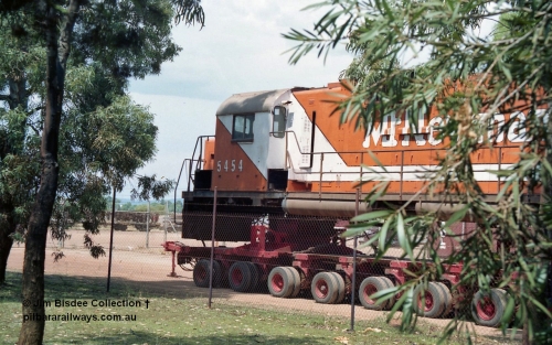 20861
Bassendean, Goninan workshops, sitting outside the locked gates having just been bought down from Port Hedland, Mt Newman Mining's AE Goodwin ALCo C636 unit 5454 serial G6012-3 on a ninety six wheel road float. 5454 will be rebuilt into CM40-8M unit 5641 by June 1992. Image taken January 1992.
Jim Bisdee photo.
Keywords: 5454;AE-Goodwin;ALCo;C636;G6012-3;
