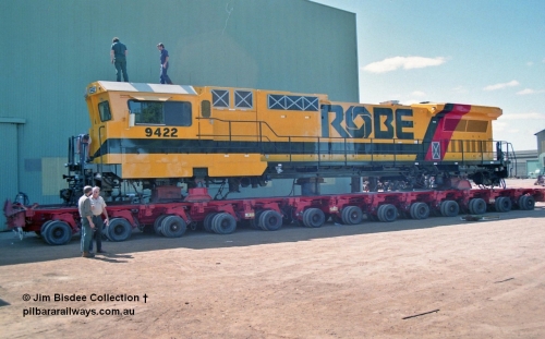 23100
Bassendean, Goninan workshops, loaded onto a hundred and four six wheel road transport float, Robe River rebuild GE CM40-8M unit 9422 serial 8297-03 / 93-138 is loaded awaiting transport to Cape Lambert. 9422 was rebuilt from Comeng NSW built ALCo M636 9422 serial C6103-2 from Aug 1977 and kept this number when rebuilt here. March 1993.
Jim Bisdee photo.
Keywords: 9422;Goninan;GE;CM40-8M;8297-03/93-138;rebuild;Comeng-NSW;ALCo;M636;C6103-2;