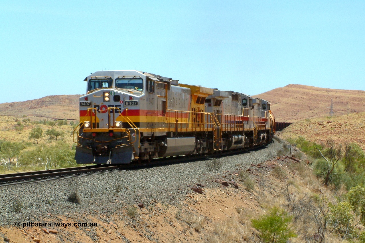 050110 120842r
North of Maitland Siding on the Deepdale line at the 83.7 km grade crossing, Robe River owned General Electric Dash 9-44CW unit 9407 serial 54157 in Pilbara Rail livery leads a pair of Hamersley Iron owned and liveried sister units 7075 serial 47754 and 7067 serial 47746 with an empty working for the Deepdale or Mesa J mine on the Robe River line with three loaded fuel tank waggons trailing the locos. Monday 10th January 2005.
Keywords: 9407;GE;Dash-9-44CW;54157;