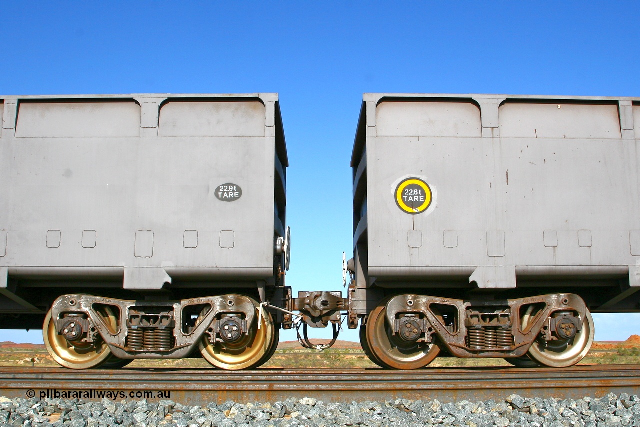 080116 1375r
Chapman Siding, view of FMG's Zhuzhou Rolling Stock Works built waggons showing the 'F' type fixed and rotary couplers between 'control' waggon 2396 and 'slave' waggon 1187. Note the difference in the tare weights, 2396 with the fixed coupler is the 'control' waggon, while 1187 is the 'slave' waggon with the rotary coupler. The yellow circle also denotes the rotary coupler end. 16th January 2008.
Keywords: CSR-Zhuzhou-Rolling-Stock-Works-China;