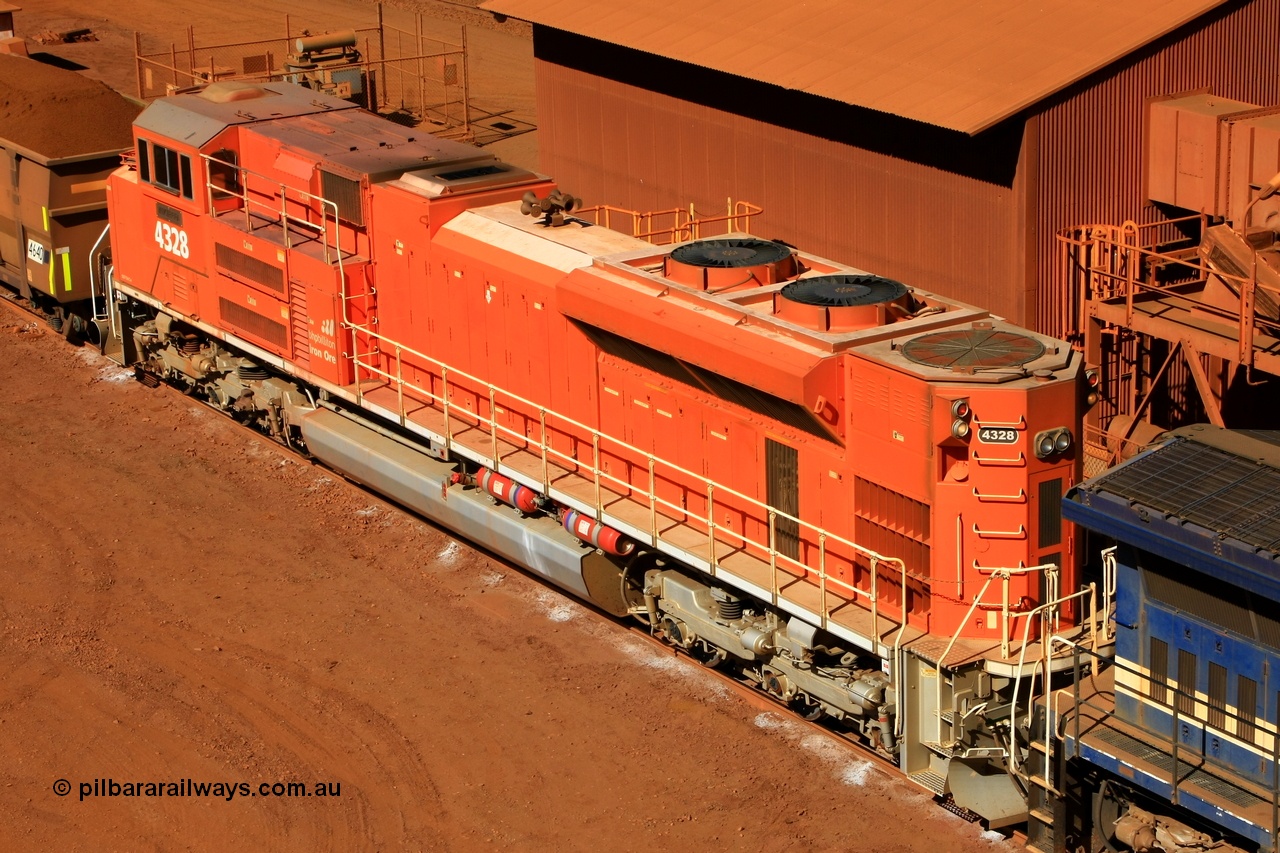 100508 8250
Nelson Point, BHP Billiton 'Pumpkin' unit 4328 was built by Electro-Motive as an EMD model SD70ACe for the BNSF railroad in the USA with serial 20066862-057 but was sold to BHP while under construction as one of ten similar units to be diverted to BHP in an all over BNSF base orange earning them the nickname of 'pumpkins' after the BNSF livery. They were standard US domestic units and required substantial modifications to be afforded lead unit status for BHP. This elevated view shows the tropical roof, non-slip paint on the hood, marker lights and modified sand fillers, rear end plough, fire suppression tanks and dual handrail. 8th May 2010.
Keywords: 4328;Electro-Motive-London-Ontario;EMD;SD70ACe;20066862-057;BNSF-9186;
