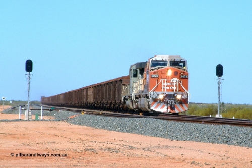 040508 113001r
Mooka Siding, BHP Billiton GE AC6000 6075 'Newman' serial 51067 and EMD SD40-2 3082 serial 786263-31 originally Union Pacific UP 3639 split the north end departure signals with a 300 waggon loaded train, the first pair of mid-train units 5633-5663 are visible, trailing are 5658-5631 and end of the train can be seen on the right. 8th May 2004.
Keywords: 6075;GE;AC6000CW;51067;