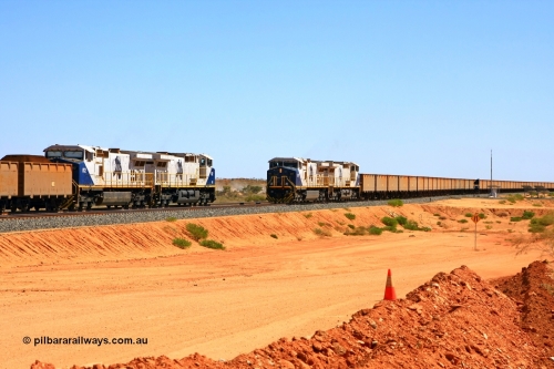 090814 2109r
Hunter Siding, the empty train takes the passing track under the power of two FMG General Electric built Dash 9-44CW units 011 serial 58188 and 010 serial 58187, while another pair of identical units 002 serial 58179 and 012 serial 58189 hold the mainline and will wait for a new PA to continue towards the port. The dust between the two trains is from the BHP access road. 14th August 2009.
Keywords: FMG-011;GE;Dash-9-44CW;58188;