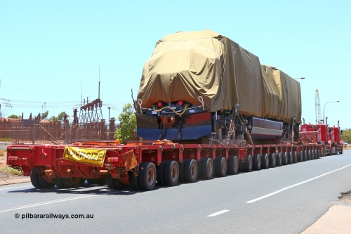 150131 7693
Port Hedland, Wilson Street, view of Roy Hill's General Electric built ES44ACi unit RHA 1014 serial 62586 still under tarp during delivery behind dual ALE Kenworth prime movers. 31st January 2015.
Keywords: RHA-class;RHA1014;GE;ES44ACi;62586;